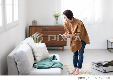 服をスマートフォンで撮影する女性 服をスマートフォンで撮影する女性 131429006
