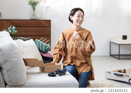 部屋を片付けながら笑顔を見せる女性 131429122