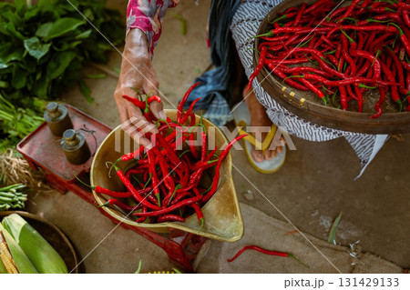 In a bustling market, vibrant red chili peppers add a colorful touch to the scene In a bustling market, vibrant red chili peppers add a colorful touch to the scene 131429133