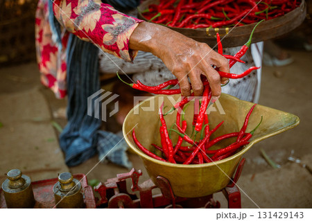 A Vibrant Market Scene Featuring Fresh, Bright Red Chilies Being Weighed with Care and Precision A Vibrant Market Scene Featuring Fresh, Bright Red Chilies Being Weighed with Care and Precision 131429143