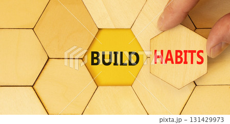 Build habits symbol. Concept word Build habits on beautiful wooden puzzles. Businessman's hand. Beautiful yellow paper background. Business build habits concept. Copy space. Build habits symbol. Concept word Build habits on beautiful wooden puzzles. Businessman's hand. Beautiful yellow paper background. Business build habits concept. Copy space. 131429973