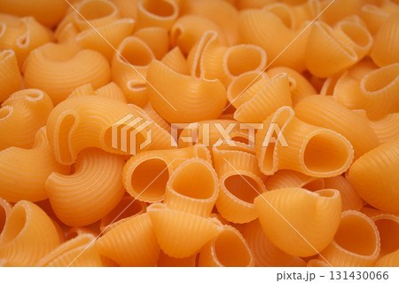 Raw pasta close-up, bright golden hue. Pasta Truba Rigate. 131430066