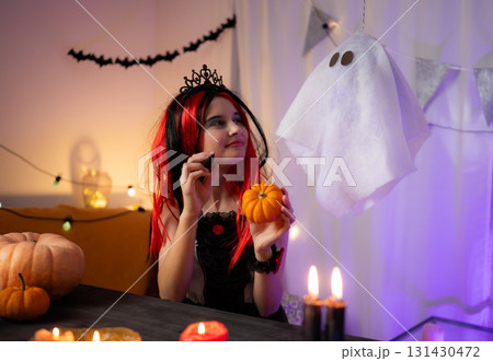 Cute Little Girl In A Halloween Witch Wig Playing And Speaking With A Pumpkin And Ghost Cute Little Girl In A Halloween Witch Wig Playing And Speaking With A Pumpkin And Ghost 131430472