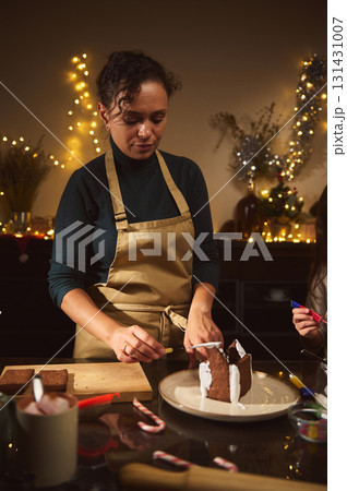 Warm Christmas Kitchen Scene With Mom And Kids Building A Gingerbread House Warm Christmas Kitchen Scene With Mom And Kids Building A Gingerbread House 131431007