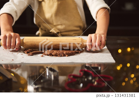 Baker Rolling Dough With Wooden Rolling Pin On Kitchen Table Baker Rolling Dough With Wooden Rolling Pin On Kitchen Table 131431381
