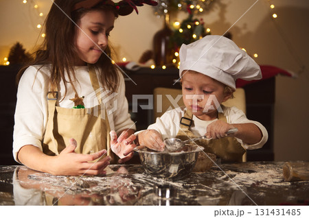 Two Kids Bake Gingerbread Together For Christmas, A Cozy Family Kitchen Scene 131431485