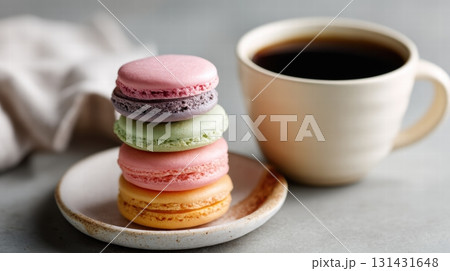 coffee and stack of colorful macarons on a pale ceramic plate 131431648