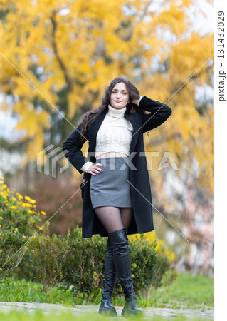 Young woman posing in autumn fashion with golden leaves Young woman posing in autumn fashion with golden leaves 131432029