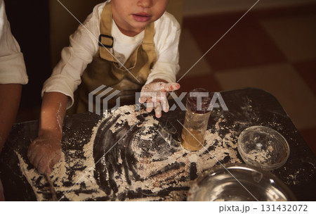 Child With Flour On Hands Baking At Cozy Kitchen Table During Playful Messy Moment 131432072