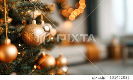 Christmas tree adorned with golden ornaments and soft glowing lights, creating a warm festive atmosphere in a cozy living room setting 131432085