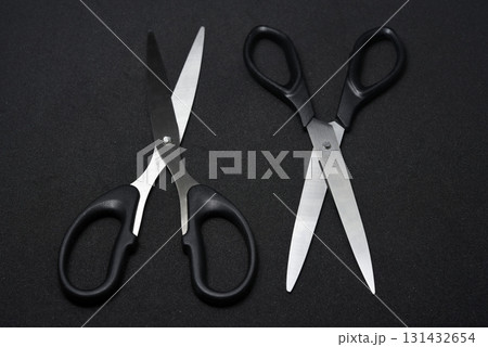 Two scissors on a black background. Stationery scissors. Two scissors on a black background. Stationery scissors. 131432654