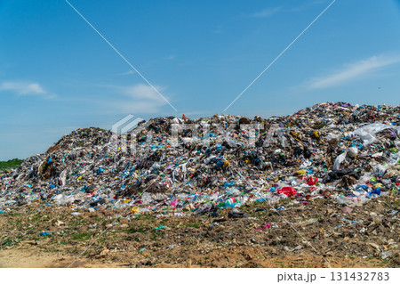 A vast accumulation of various types of waste covers the ground at a landfill, with a bright blue sky overhead A vast accumulation of various types of waste covers the ground at a landfill, with a bright blue sky overhead 131432783