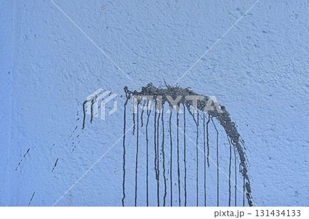 The coarse texture of a dark blue wall with a bold stain. The rough texture of a deep blue wall with an ink blot. The concept of background and textured surface. 131434133