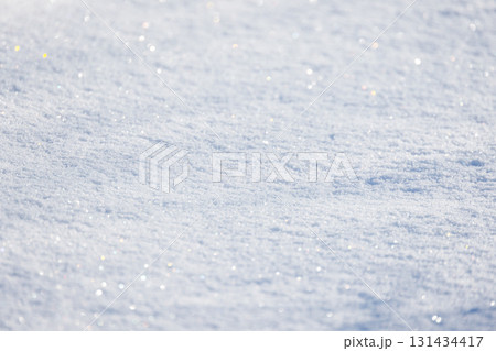 A sunlit, snow-covered ground glistens with tiny crystals, background photo texture A sunlit, snow-covered ground glistens with tiny crystals, background photo texture 131434417