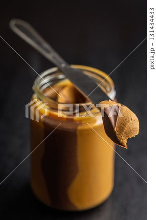 Two-tone nut chocolate spread in jar on black table. Two-tone nut chocolate spread in jar on black table. 131434433