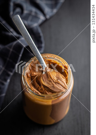 Two-tone nut chocolate spread in jar on black table. Two-tone nut chocolate spread in jar on black table. 131434434
