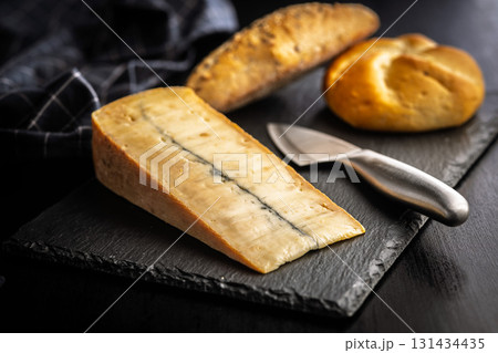 Morbier cheese. Delicious french cheese with mold on black table. 131434435