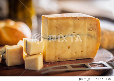 Morbier cheese. Delicious french cheese with mold on cutting board on wooden table. Morbier cheese. Delicious french cheese with mold on cutting board on wooden table. 131434450