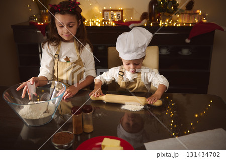 Two Kids Baking Gingerbread Cookies Together for Christmas in Cozy Home Kitchen Two Kids Baking Gingerbread Cookies Together for Christmas in Cozy Home Kitchen 131434702