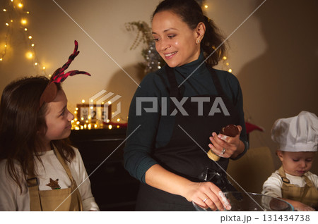Joyful Mother With Kids Baking Gingerbread In Cozy Christmas Kitchen 131434738