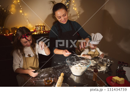 Happy Family Baking Christmas Cookies And Gingerbread In Cozy Home Kitchen With Fairy Lights 131434739