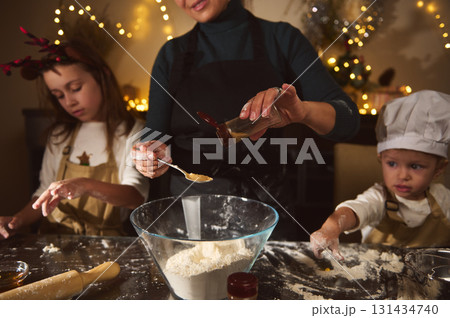 Family Christmas Baking: Mother and Kids Make Gingerbread House Amid Cozy Holiday Kitchen Family Christmas Baking: Mother and Kids Make Gingerbread House Amid Cozy Holiday Kitchen 131434740