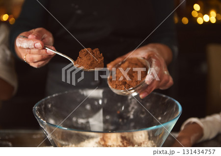 Hands Sifting Cocoa Into A Bowl For Gingerbread House In Cozy Christmas Kitchen Hands Sifting Cocoa Into A Bowl For Gingerbread House In Cozy Christmas Kitchen 131434757