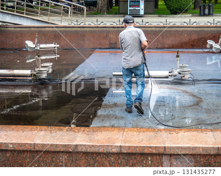 Empty fountain in a city park. Dehumidification. Cleaning the fountain with a hose. The device of the fountain. Pipes for water supply. Water hoses. Modern technologies. Infrastructure maintenance. 131435277
