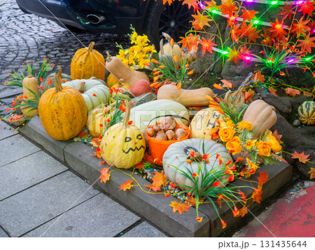 Decorations for Halloween on the street near the restaurant. Pumpkins are placed near the tree. Restaurant patio decoration. Painted multi-colored pumpkins. All Saints' Day. The holiday is Decorations for Halloween on the street near the restaurant. Pumpkins are placed near the tree. Restaurant patio decoration. Painted multi-colored pumpkins. All Saints' Day. The holiday is 131435644