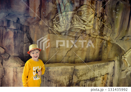 A toddler in a yellow tshirt is exploring a temple with intricate wood carvings and ancient wall art. It is a leisurely travel experience filled with visual arts A toddler in a yellow tshirt is exploring a temple with intricate wood carvings and ancient wall art. It is a leisurely travel experience filled with visual arts 131435992