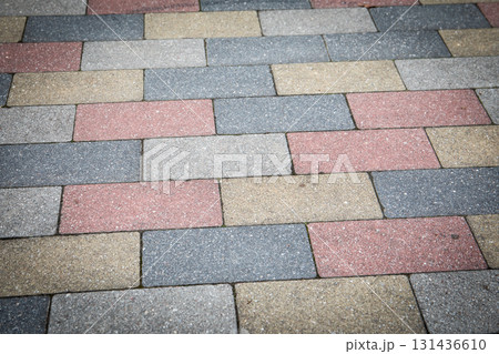 Colorful Paving Stone Pattern on Urban Sidewalk with Concrete Texture and Geometric Arrangement 131436610