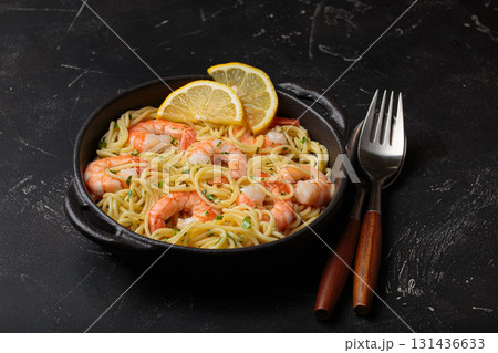 Delicious seafood pasta spaghetti with shrimps dish garnished with lemon and parsley anglr view on black background 131436633