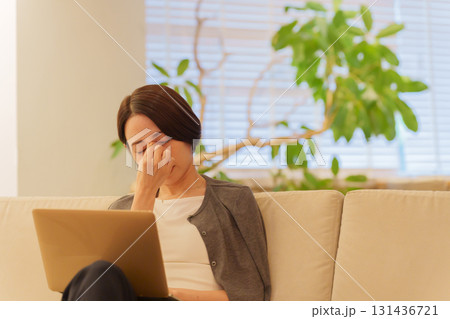 夜パソコンで仕事する眼精疲労の女性 夜パソコンで仕事する眼精疲労の女性 131436721