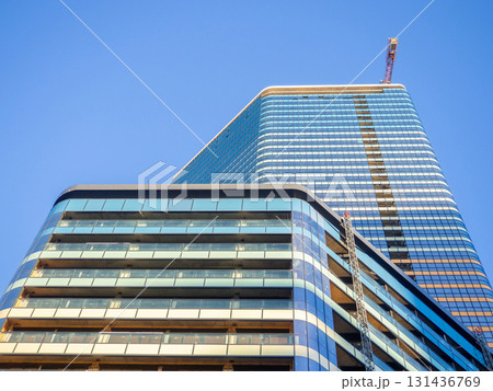A newly built house. Glazed skyscraper. Reflection of the sky in the windows. Multi-apartment modern housing. A newly built house. Glazed skyscraper. Reflection of the sky in the windows. Multi-apartment modern housing. 131436769