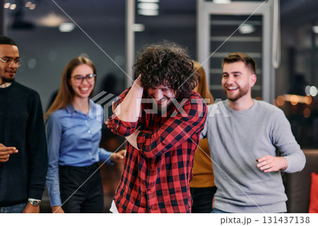 A group of young business people have fun playing interesting games while taking a break from work in a modern office. Selective focus A group of young business people have fun playing interesting games while taking a break from work in a modern office. Selective focus 131437138