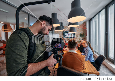 Capturing Corporate Dynamics: Videographer Films Business Meeting in Modern Office. 131437188
