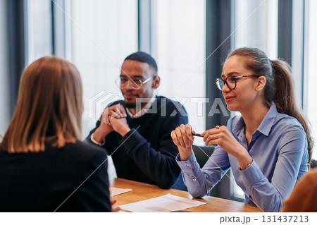 In the vibrant ambiance of a modern startup office, a diverse team of business professionals engage in discussions on various projects and develop new business strategies, epitomizing creativity and In the vibrant ambiance of a modern startup office, a diverse team of business professionals engage in discussions on various projects and develop new business strategies, epitomizing creativity and 131437213