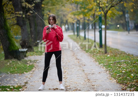 Athletic young woman taking a breath and relaxing after jogging and stretching. Woman Training and Workout Exercises On Street. Athletic young woman taking a breath and relaxing after jogging and stretching. Woman Training and Workout Exercises On Street. 131437235