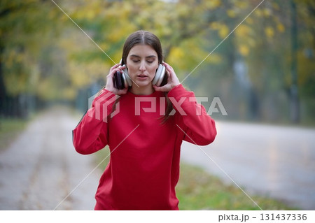 Athletic young woman taking a breath and relaxing after jogging and stretching. Woman Training and Workout Exercises On Street. 131437336