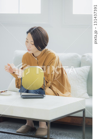 リビングで鏡を見る女性 131437391
