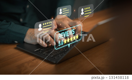 Hands typing on laptop computer with glowing 5 star review icons, symbolizing positive customer feedback, online ratings, testimonial, and excellent service reputation in digital business platforms. 131438118