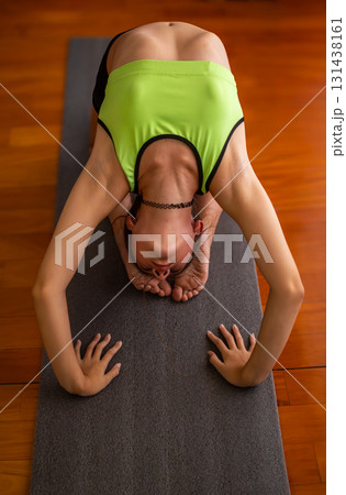 Teenager stretching surrounded by natural light, ideal for wellness projects. 131438161