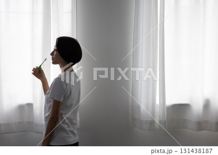 窓辺で歯磨きをするミドル女性 131438187