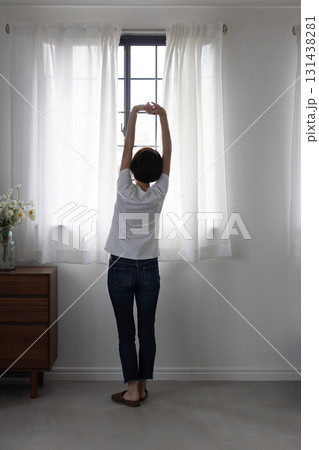 窓辺でストレッチする女性の後ろ姿 131438281
