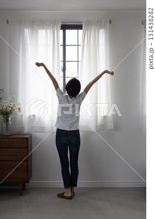 窓辺でストレッチする女性の後ろ姿 131438282