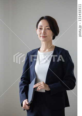 屋内を歩くミドル世代のスーツ姿の女性 131438311