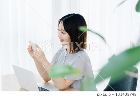オフィスでスマホを見るビジネスウーマン オフィスでスマホを見るビジネスウーマン 131438749