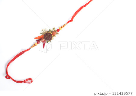 Decorative rakhi with red thread and decorations on a white background Decorative rakhi with red thread and decorations on a white background 131439577