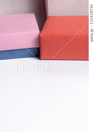 Colorful gift boxes with pink, orange and blue wrapping on a white surface for celebration and gifts. Colorful gift boxes with pink, orange and blue wrapping on a white surface for celebration and gifts. 131439730