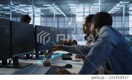 Engineer arrives in data center, puts headphones on, implementing AI systems. Server farm expert sitting down at desk, listening music and using artificial intelligence to prevent failures, camera A 131439917